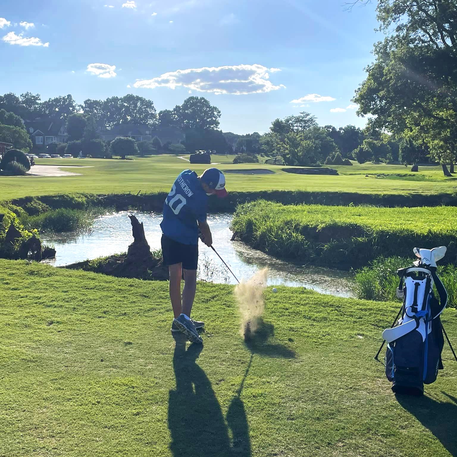 junior golfer taking swing on golf course